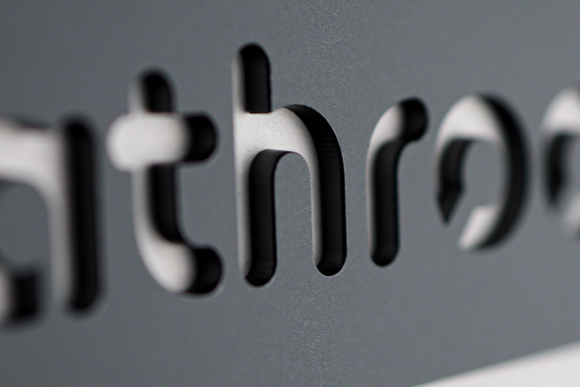 Sleek modern black acrylic bathroom sign with minimalist cut-out typography.