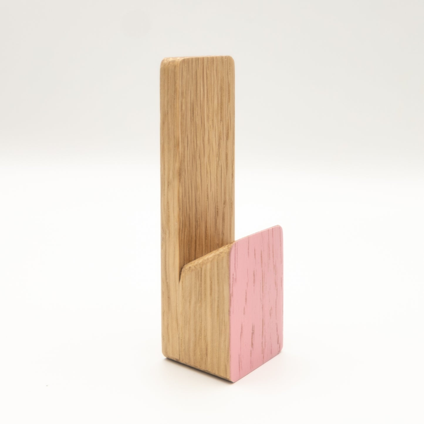 Wooden and pink phone stand on a white background