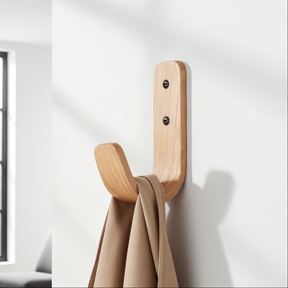 Wooden wall hook with a beige towel on a white wall